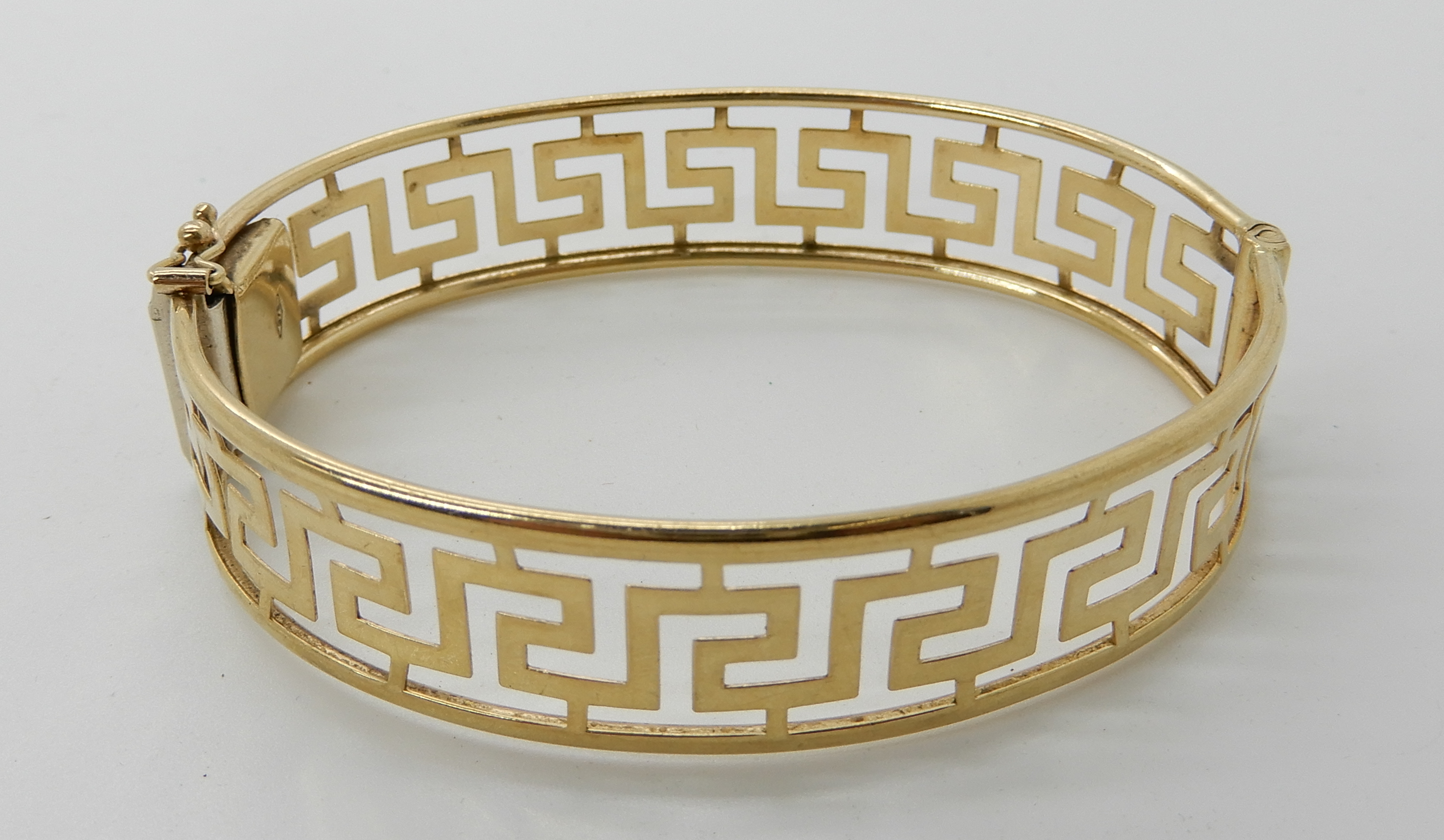 A 9ct gold Greek key pattern bangle, inner dimensions 6.5cm x 5.4cm, weight 14.5gms Condition