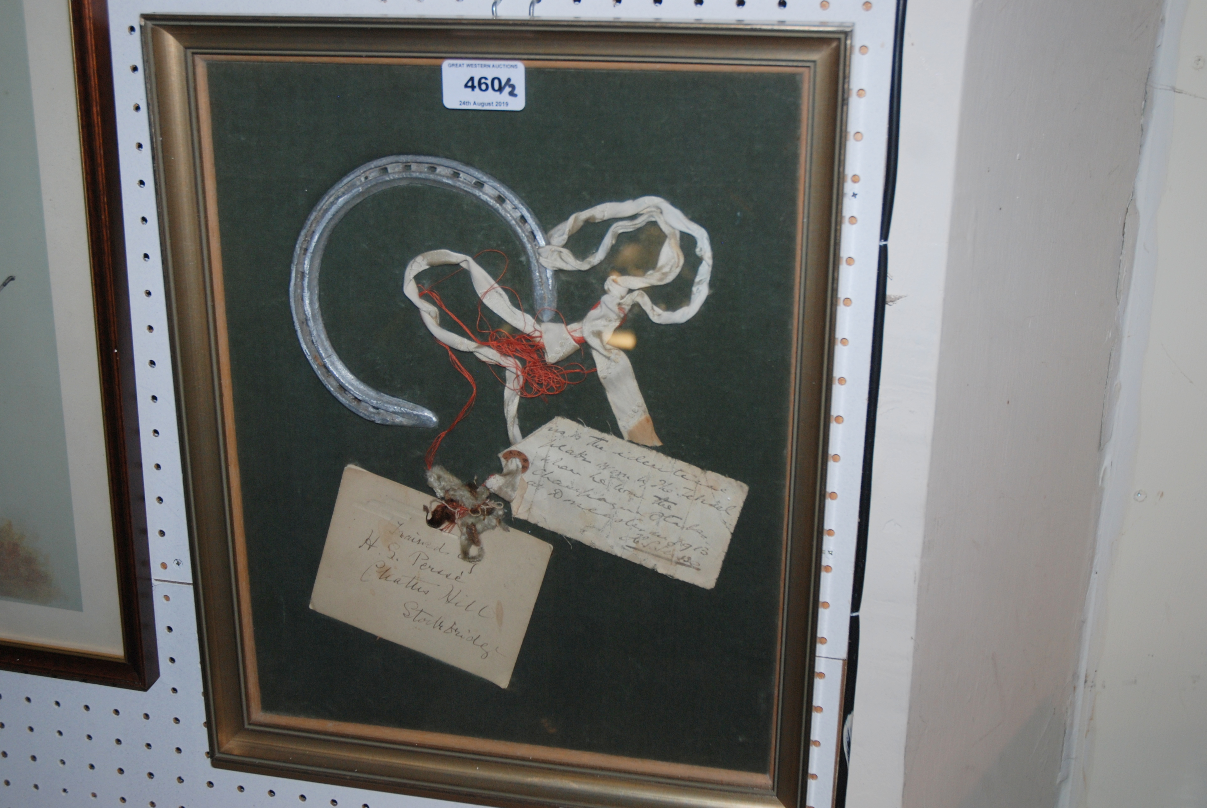 A framed display with horseshoe with note reading This is an identical plate believed to have worn