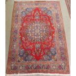 A RED GROUND TABRIZ RUG with blue central medallion and matching spandrels with multiple borders,