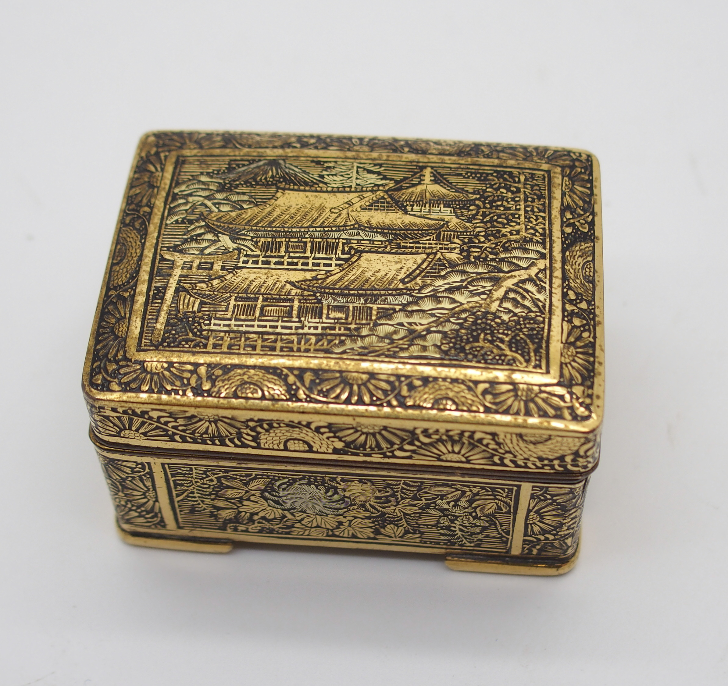 A JAPANESE KOMAI SMALL BOX the hinged cover decorated with buildings in a mountainous landscape, the