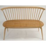 A LIGHT ERCOL STICK BACK BENCH on tapered legs with turned stretcher, 82cm high x 112cm wide x