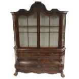 A DUTCH WALNUT DISPLAY CABINET the carved foliate scroll surmount above a pair of astragal doors,