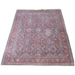 A BLUE GROUND EASTERN RUG with small medallions and floral design within a red main border, 380cm