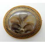 A BRIGHT YELLOW METAL HAIR ART MOURNING BROOCH with black enamel decorative border and Victorian