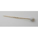 A YELLOW METAL MOUNTED PEARL TOPPED PIN the pearl with subtle lustre is drop shaped approx 10mm x