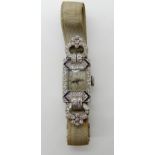 A PLATINUM ART DECO DIAMOND SET COCKTAIL WATCH with unusual flower motifs. Estimated approx combined
