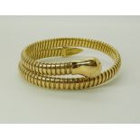 A BRIGHT YELLOW METAL SNAKE BANGLE of sprung construction, inner diameter approx 5.5cm relaxed,