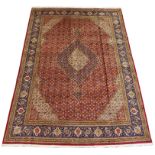 A RED GROUND TABRIZ RUG with a cream and blue central medallion, cream spandrels and a blue floral