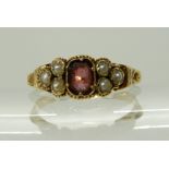 A BRIGHT YELLOW METAL VICTORIAN GARNET AND PEARL SET RING with engraved shoulders and shank, size P,