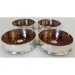 A SET OF FOUR SILVER WINE COASTERS by Douglas Pell Silverware, London 1997, of plain circular form