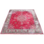 A DEEP PINK GROUND THICK PILE WOOL RUG with central floral pattern and matching spandrels and a pale