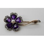 AN AMETHYST AND ROSE CUT DIAMOND FLOWER BROOCH mounted in yellow and white metal, dimensions 3.2cm x