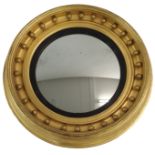 A 19TH CENTURY GILT FRAMED CONVEX CIRCULAR WALL MIRROR the deep frame set with ball surmounts,