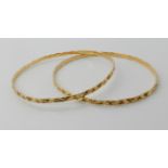TWO BRIGHT YELLOW METAL PATTERNED BANGLES inner diameter 6.3cm, width of bangles approx 2.8mm,