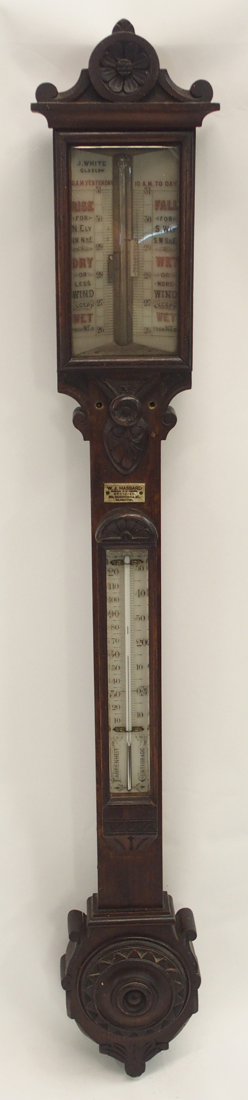 A VICTORIAN CARVED MAHOGANY BAROMETER/THERMOMETER by J White, Glasgow, retailed by W J Hassard,