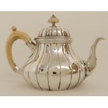 A VICTORIAN SILVER TEAPOT by Robert Garrard, London 1855, of bulbous baluster form with ribbed body,