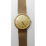 A 9CT GOLD GENTS OMEGA DEVILLE MANUAL WIND WRISTWATCH with a gold coloured dial and baton