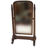A VICTORIAN MAHOGANY CHEVAL MIRROR on tapered supports with acanthus leaf decoration on four