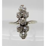 A SEVEN STONE DIAMOND LINEAR CLUSTER RING the seven old cut diamonds are claw set in an elegant