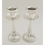 A PAIR OF WHITE METAL CANDLESTICKS (POSSIBLY ISRAEL SILVER) unknown marks, with integral drip