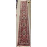 A RED GROUND BIDJAR RUNNER with six lozenges, 545cm x 81cm Condition Report: Available upon request