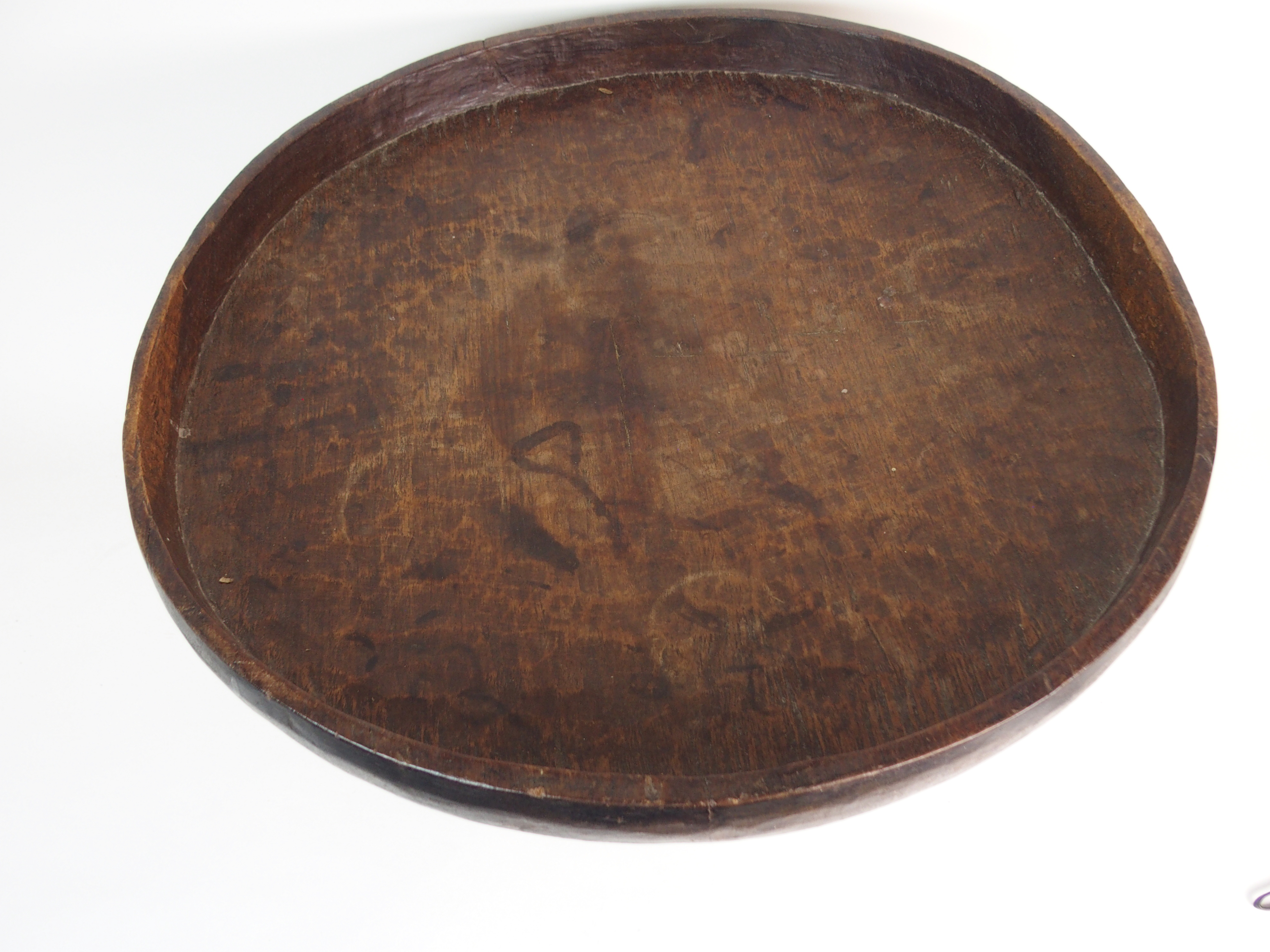 *WITHDRAWN* AN AFRICAN TRIBAL HARDWOOD CIRCULAR TABLE with deep carved rim above a pair of curved - Image 2 of 8