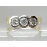 AN 18CT GOLD THREE STONE DIAMOND RING of estimated approx 0.50cts combined, in unusual twist