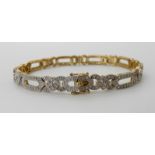 A 9CT GOLD DIAMOND SET BRACELET of alternate oblong and flower links set with estimated approx 1ct