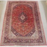 A RED GROUND KESHAN RUG with blue central medallion with matching spandrels and main border, 350cm x