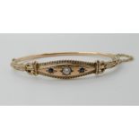 A 9CT GOLD SAPPHIRE AND DIAMOND CLASSICAL REVIVAL BANGLE with wire work detail, diamond estimated