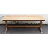 A LARGE OAK REFECTORY TABLE with stretcher and having a North of England School Furnishing Company