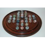 A COLLECTION OF VICTORIAN MARBLES approx 2.5cm diameter on turn wood solitaire board, 28cm