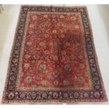 A RED GROUND KESHAN RUG with allover floral design with main blue border with floral palmettes,