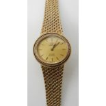 A 9CT GOLD LADIES OMEGA DE VILLE QUARTZ WRISTWATCH with gold coloured dial and baton numerals,