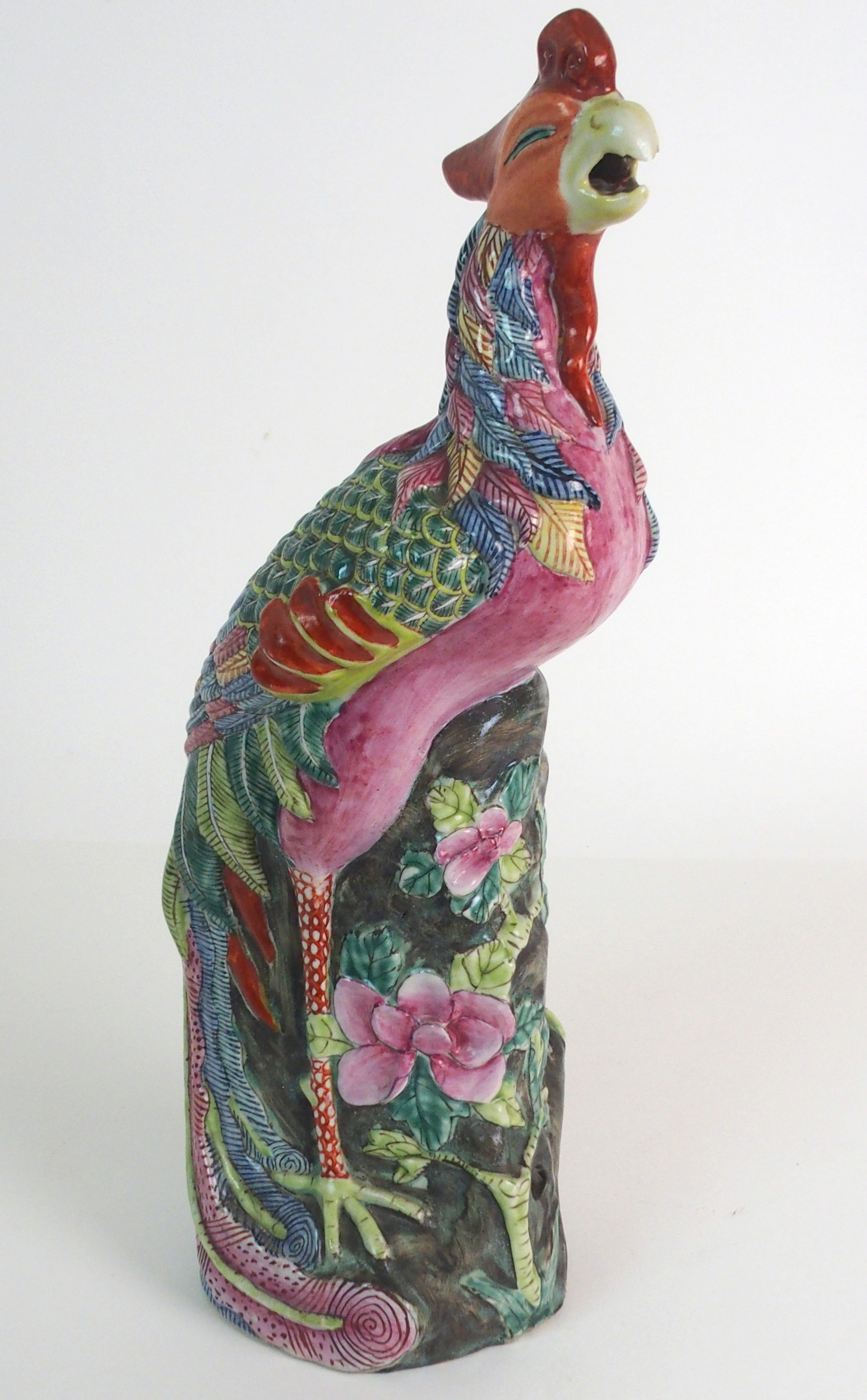 A CHINESE FAMILLE ROSE MODEL OF A PEACOCK brightly coloured and standing on pierced rockwork, 36.5cm