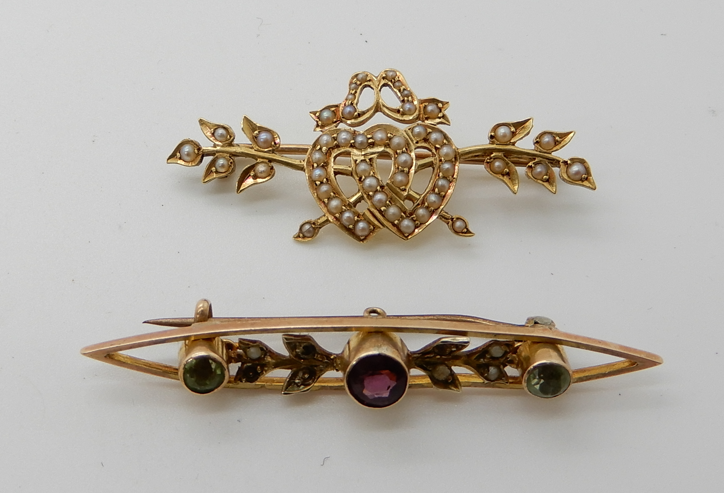 A bright yellow metal pearl set brooch with double heart motif and a 9ct gold peridot and garnet