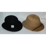 A black bowler hat, 20 x 16cm, a pith helmet and a silver-topped walking cane (3) Condition
