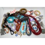 A string of amber beads, a collection of statement beads, bangles and earrings Condition Report: Not