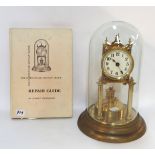 A German brass clock under glass dome, together with a Horolovar four hundred day clock repair guide