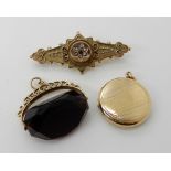 A 9ct purple glass fob seal, a 9ct back and front locket and a 9ct gold brooch, weight 15.5gms