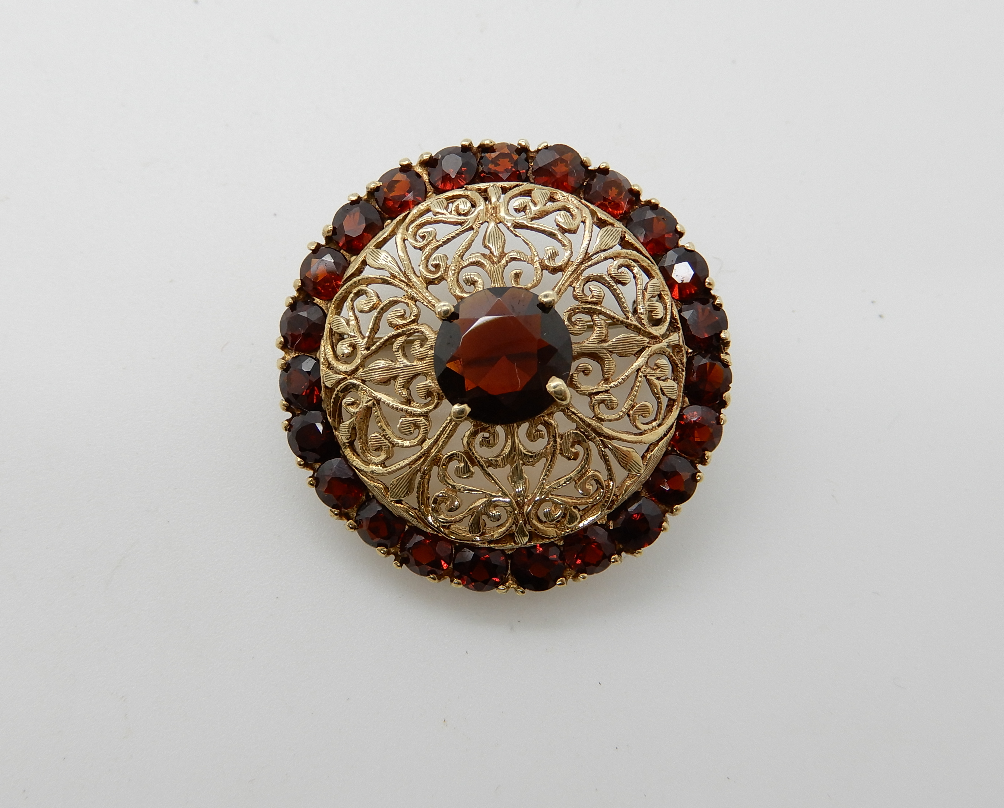 A 9ct gold garnet set brooch, diameter 2.7cm, weight 5.7gms Condition Report: Available upon