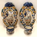 A pair of faience glazed wall fonts decorated in relief with sheep and a sceptre, 28cm high