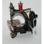A miniature black painted sewing machine Condition Report: Available upon request