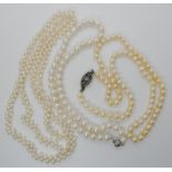 A string of cream pearls with good lustre and a white metal gem set clasp, a string of white pearls,