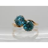 A yellow metal ring set with twin blue zircons, size P1/2, weight 4gms Condition Report: Available