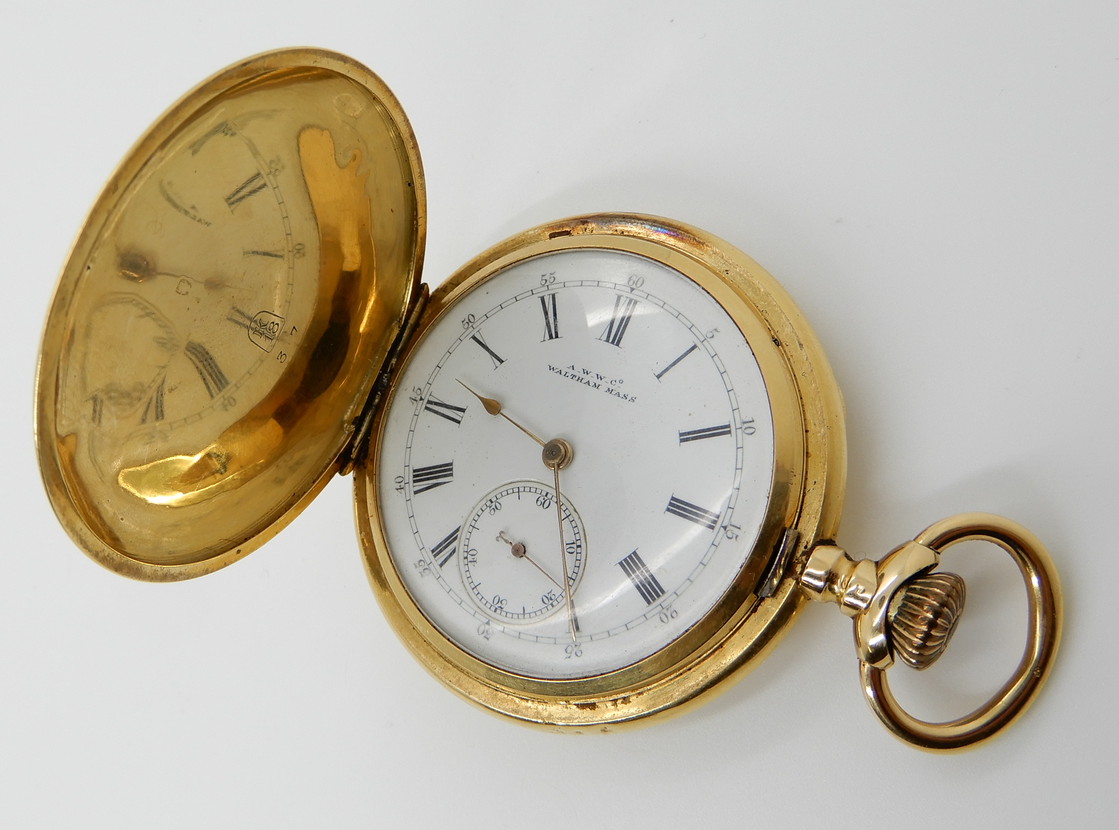 AN 18CT GOLD WALTHAM FULL HUNTER POCKET WATCH with white enamel dial, black Roman numerals, and