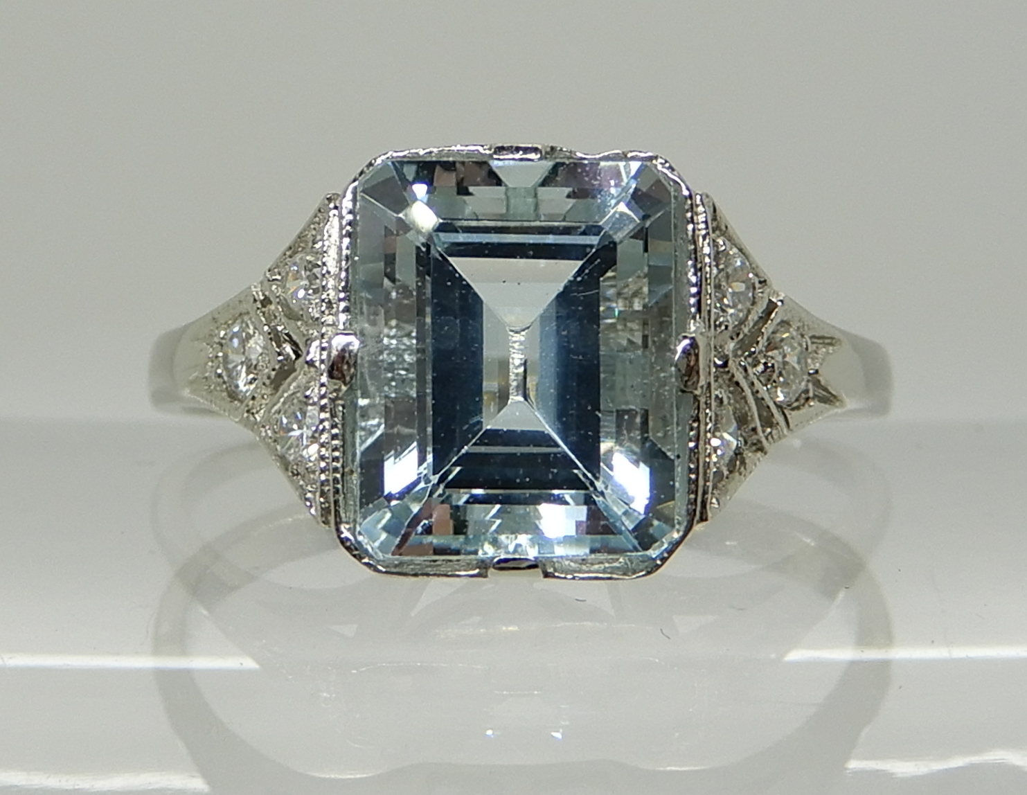 A PLATINUM AQUAMARINE AND DIAMOND RING the step cut aquamarine measures ...