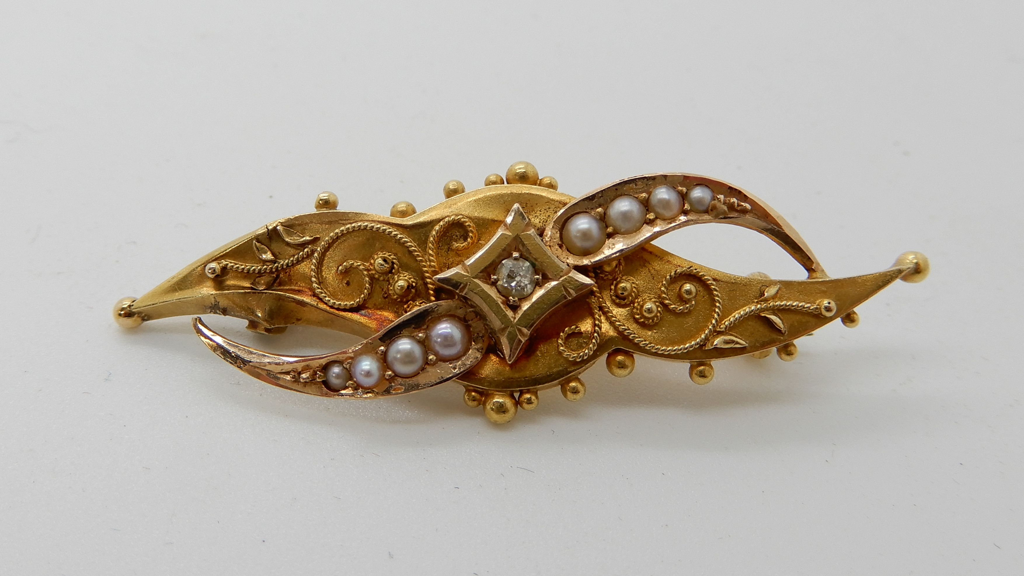 A 15ct gold pearl and diamond brooch, length 4.5cm, weight 2.6gms Condition Report: Available upon