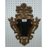 A carved gilt-wood mirror, 39cm high Condition Report: Available upon request