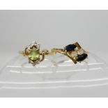 A 14k gold peridot and diamond ring, size O1/2 and a 14k sapphire and clear gem set ring, size O1/2,